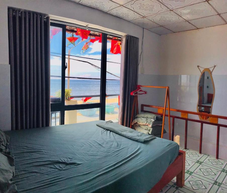 a bedroom with a bed and a view of the ocean at Homestay Bảo Nhi in Chợ Phước Hải