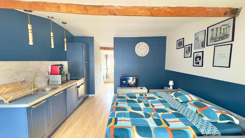 a blue room with a bed and a sink at Le Photographe Cosy Douai centre in Douai