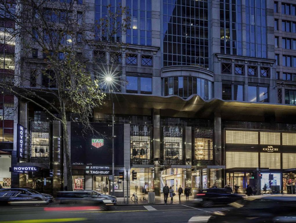 a busy city street with cars in front of a building at Novotel Melbourne On Collins in Melbourne