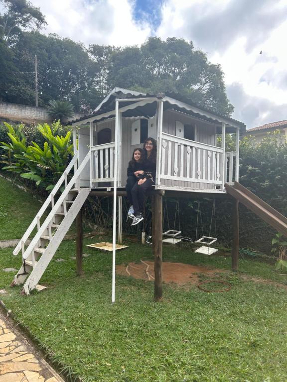 two people sitting in a tree house at Casa Ohana - Miguel Pereira in Miguel Pereira