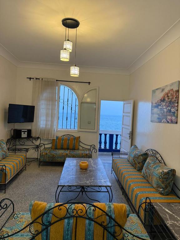 a living room with couches and a view of the ocean at front of beach apartement taghazout in Taghazout