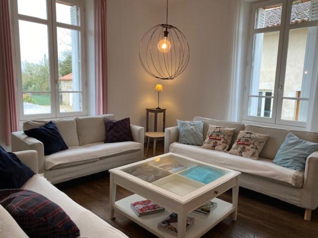 ein Wohnzimmer mit Sofas und einem Couchtisch in der Unterkunft La Maison d'Elise in Usson-du-Poitou