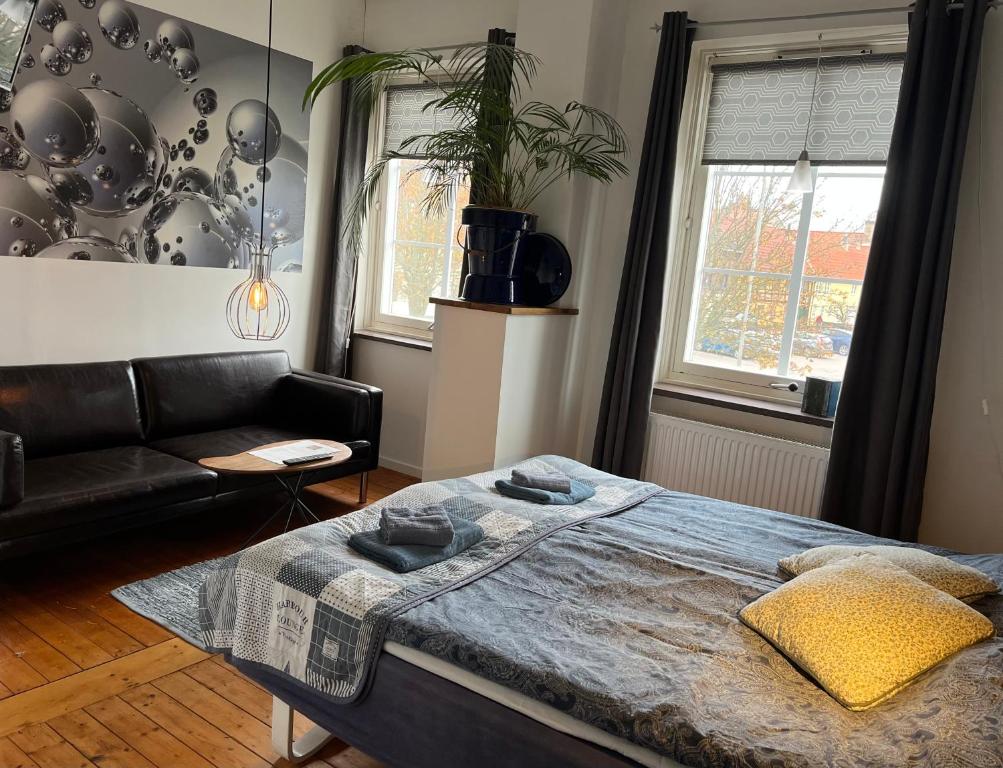 a bedroom with a bed and a couch at Sveriges minsta Hotell! Hôtel Gruyère in Landskrona