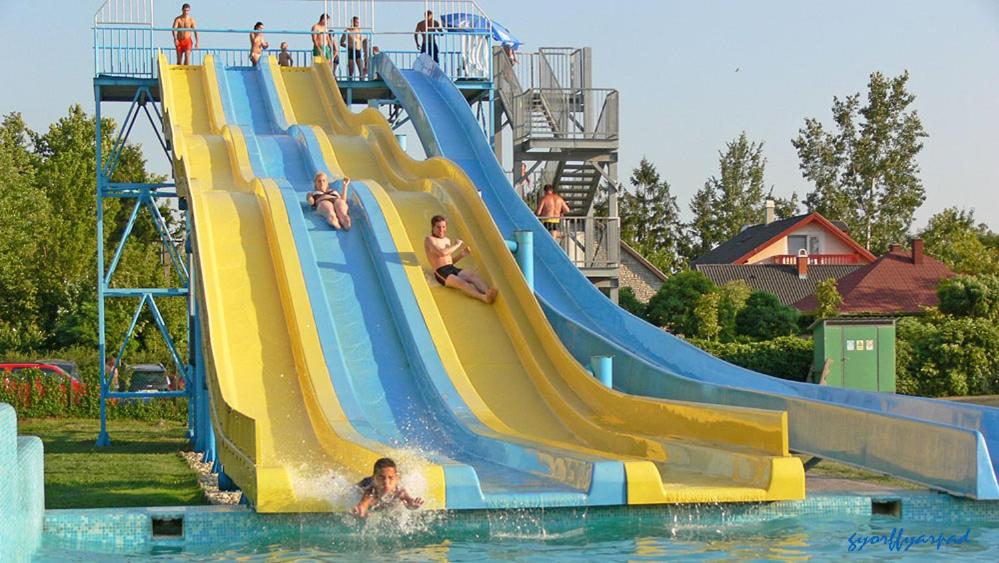 a group of people on a water slide at a water park at Beach Apartman by HelloBalatonlelle in Balatonlelle