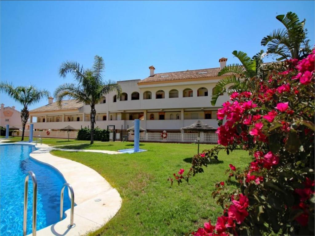 a resort with a swimming pool and pink flowers at Duplex penthouse with 4 bedrooms and stunning sea views in Benalmádena