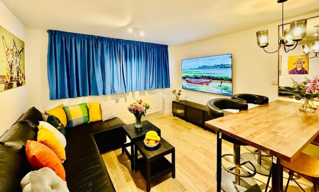 a living room with a couch and a wooden table at Central Apartment with 75inch TV Netflix in Andover