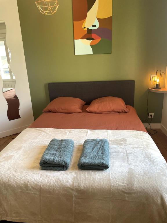 two towels on a bed in a bedroom at Charming house with terrace in Laval