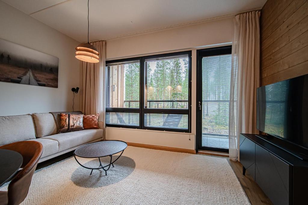 a living room with a couch and a large window at Levillas Levin Cranberry C24 in Levi