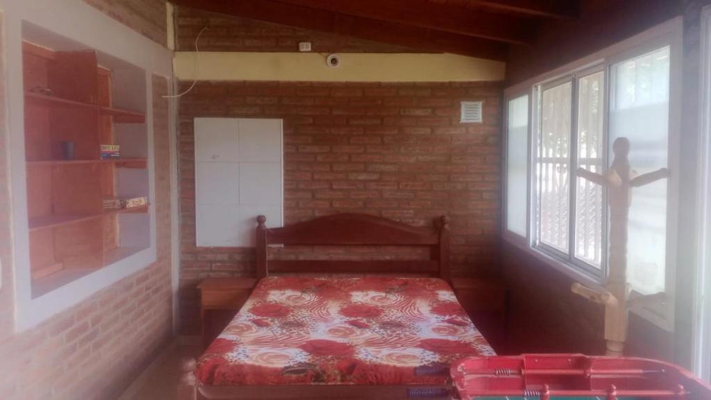 a small room with a bed in a brick wall at Laura in Santa Rosa de Calamuchita