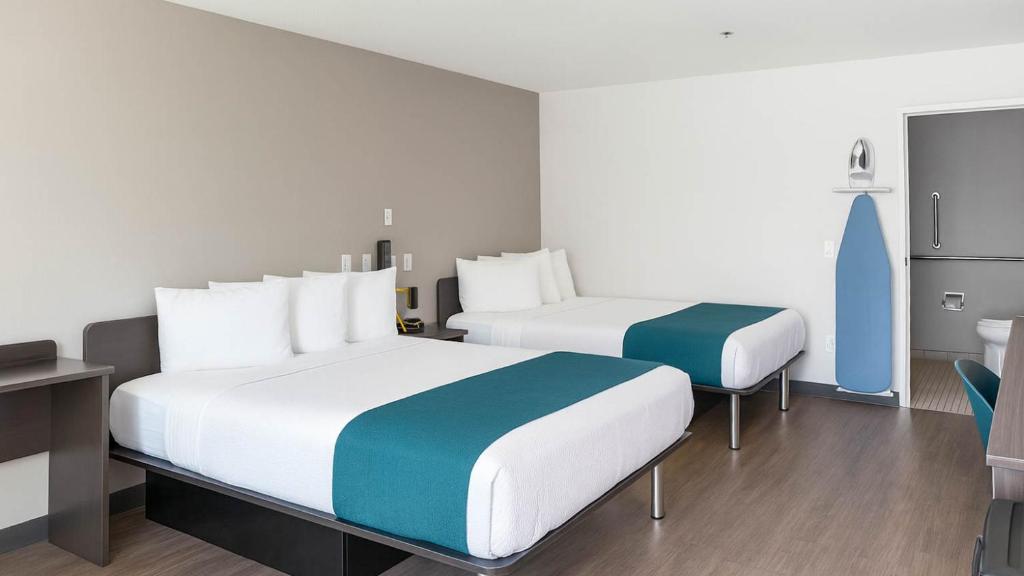 een hotelkamer met twee bedden en een bureau bij Motel 6-Anaheim, CA - Maingate in Anaheim