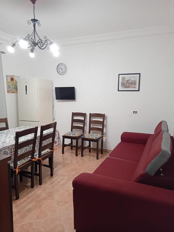 Una sala de estar con un sofá, una mesa y sillas. en Dolce Rifugio, en Siculiana