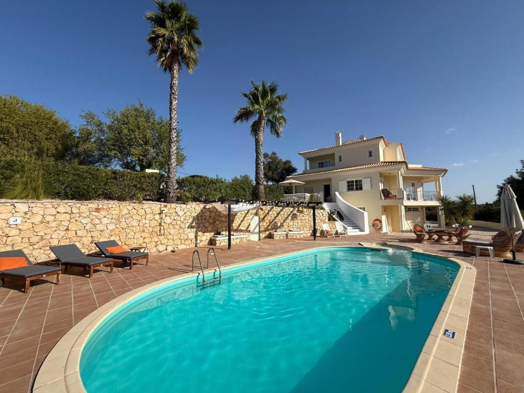 ein großes Schwimmbad vor einem Haus in der Unterkunft Villa Botanica in Canhestros