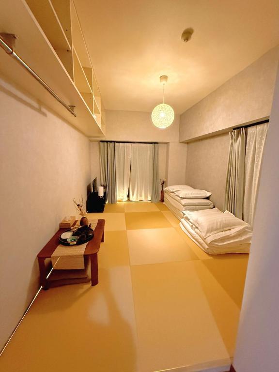 a large room with a bed and a table at Wa Shinsaka 902 7minute walk from Shinsakacho Station Maximum 4 people Separate bath and toilet Washing machine with dryer in Nagoya