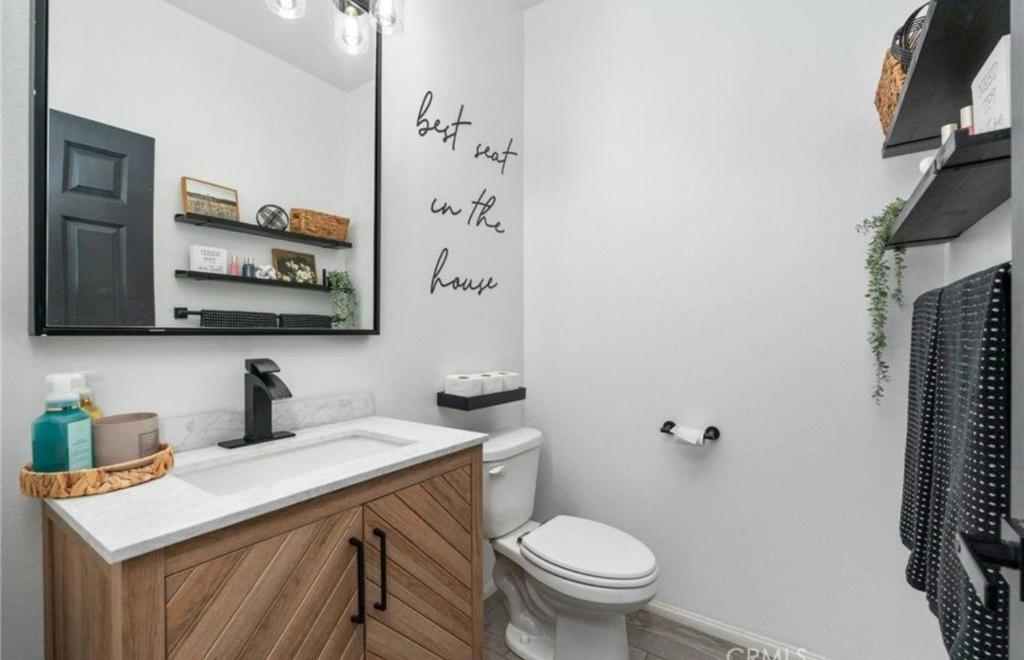 a bathroom with a toilet and a sink and a mirror at North Fontana pool house in Fontana