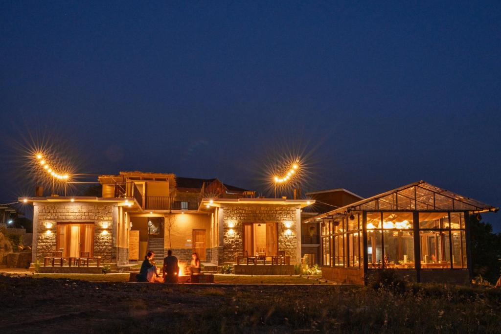 een huis 's nachts verlicht met lichtjes bij The Winter Courtyard by AVVAs Stays in Bir