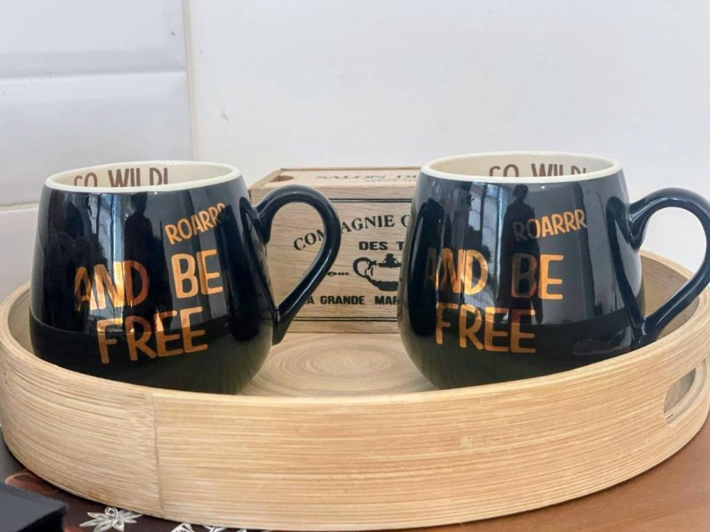 two coffee mugs on a wooden tray with a bundle of cash at Momy's Home Rome in Rome