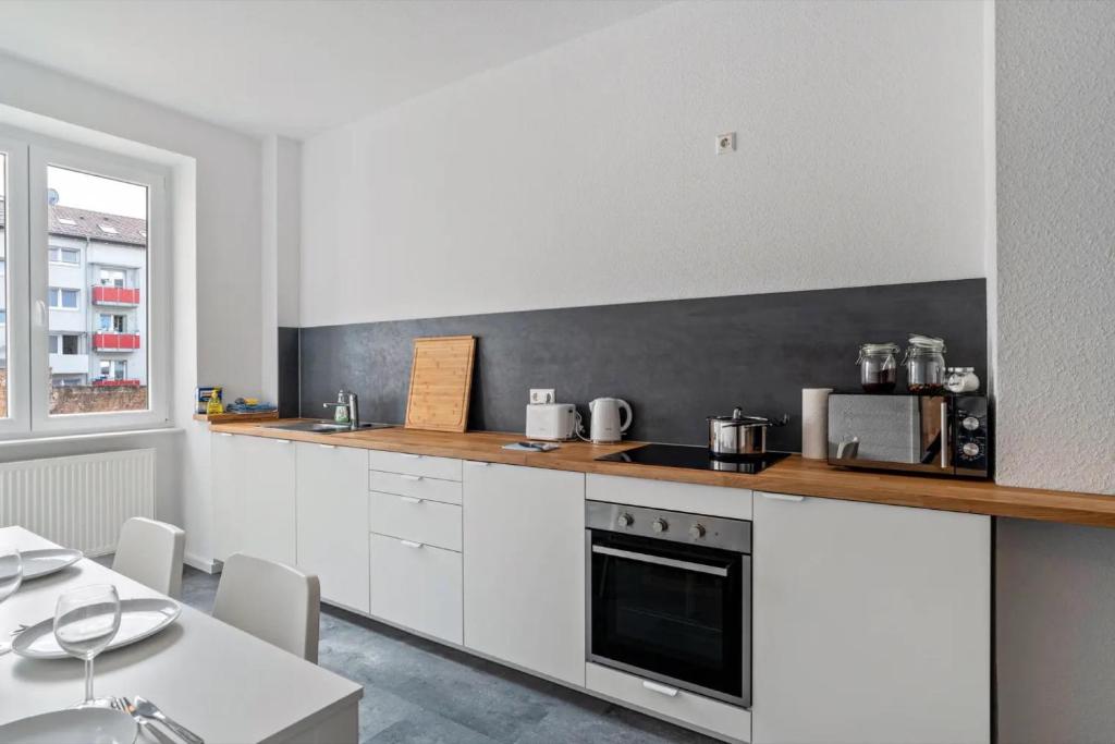 a kitchen with white cabinets and a counter top at Hallerstraße - 4 Wohnungen in Pforzheim