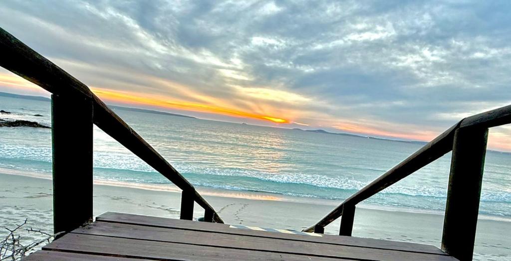 a wooden staircase leading to the beach at sunset at Langebaan Beach Towers in Langebaan
