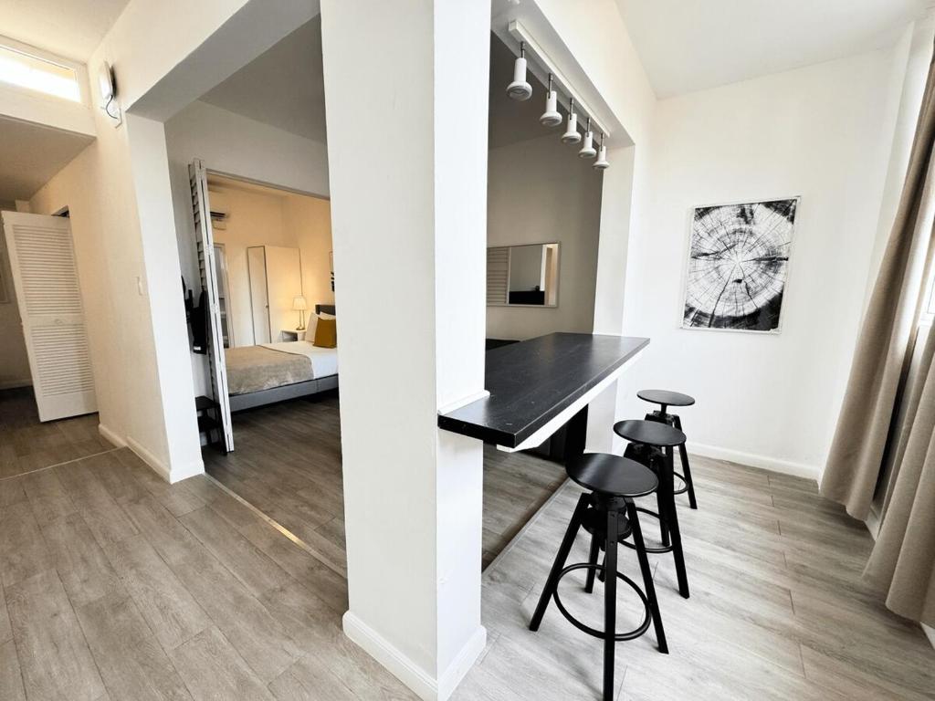 a kitchen and living room with a black counter and stools at Villas at Auxilio Mutuo 103 in San Juan
