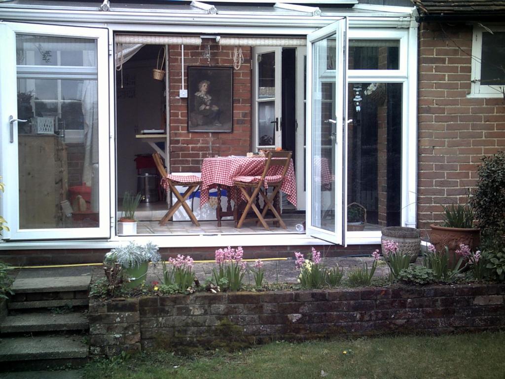 a patio with a table and chairs in a house at 80 Rushes Road, Petersfield GU32 3BP in Petersfield