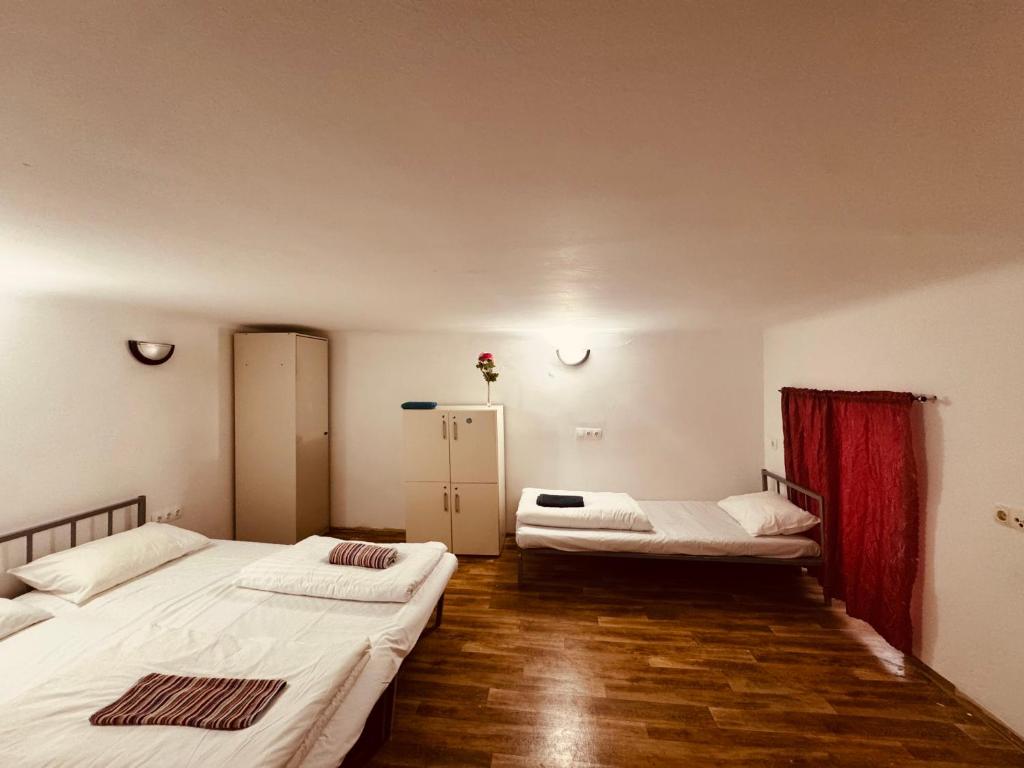 two beds in a room with wooden floors at Opera Central Stay in Budapest