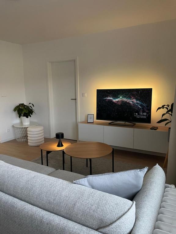 Una sala de estar con un sofá y un televisor en la pared. en Apartmán Sihoť - pri Zimnom Štadióne, en Trenčín