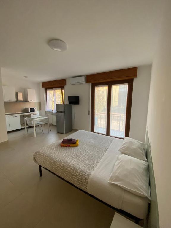a bedroom with a large bed and a kitchen at RESIDENCE Erminia in Novara