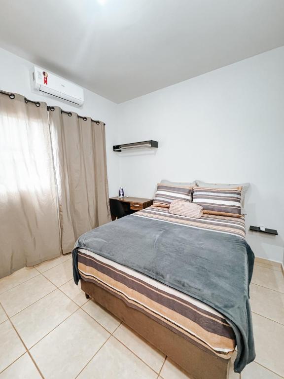 a bedroom with a large bed in a room at Apto Térreo Ótima localização Com AC in Três Lagoas