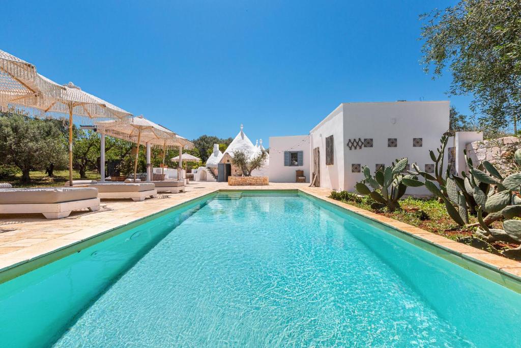 une piscine devant une maison dans l'établissement O` Trullo Mio by Perle di Puglia, à Ostuni