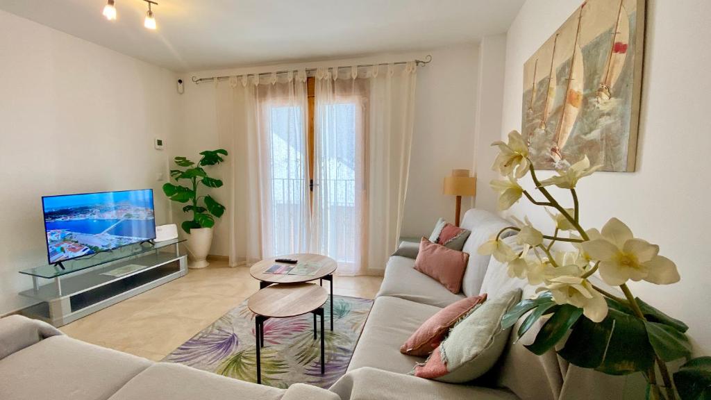 a living room with a couch and a tv at Brisas de Guadalest in El Castell de Guadalest