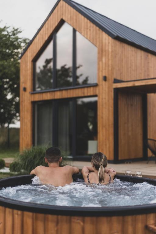 a man and a woman sitting in a hot tub at Okno Na Ślężę in Sady