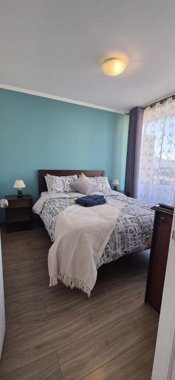 a bedroom with a bed with a blanket on it at Departamento Salar in Calama
