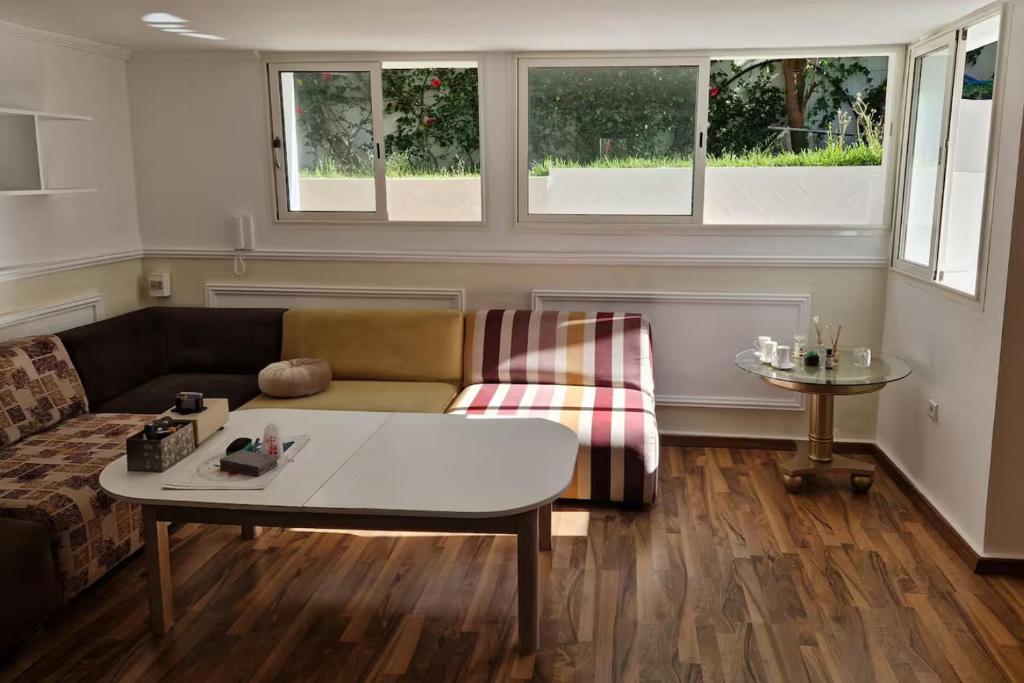 a living room with a couch and a table at 2 Bed Villa Sleeps 4 - Garden Wifi Parking in Temara