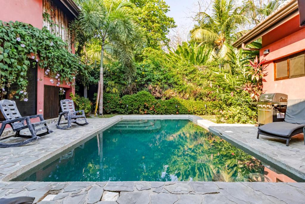 una piscina con 2 sillas junto a una casa en VIP La Lora Beach Villa best family home, en Santa Teresa Beach