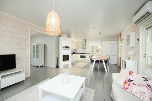 a white living room with a couch and a table at Villa Metsola in Kalajoki