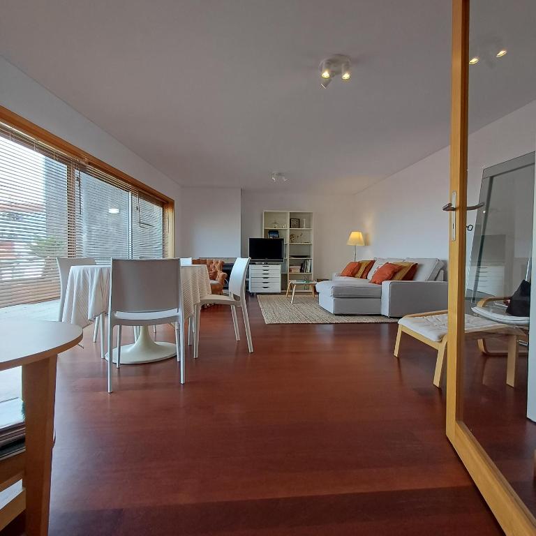 a living room with a couch and a table and chairs at Tasteful Beach Getaway with Private Terrace in Matosinhos