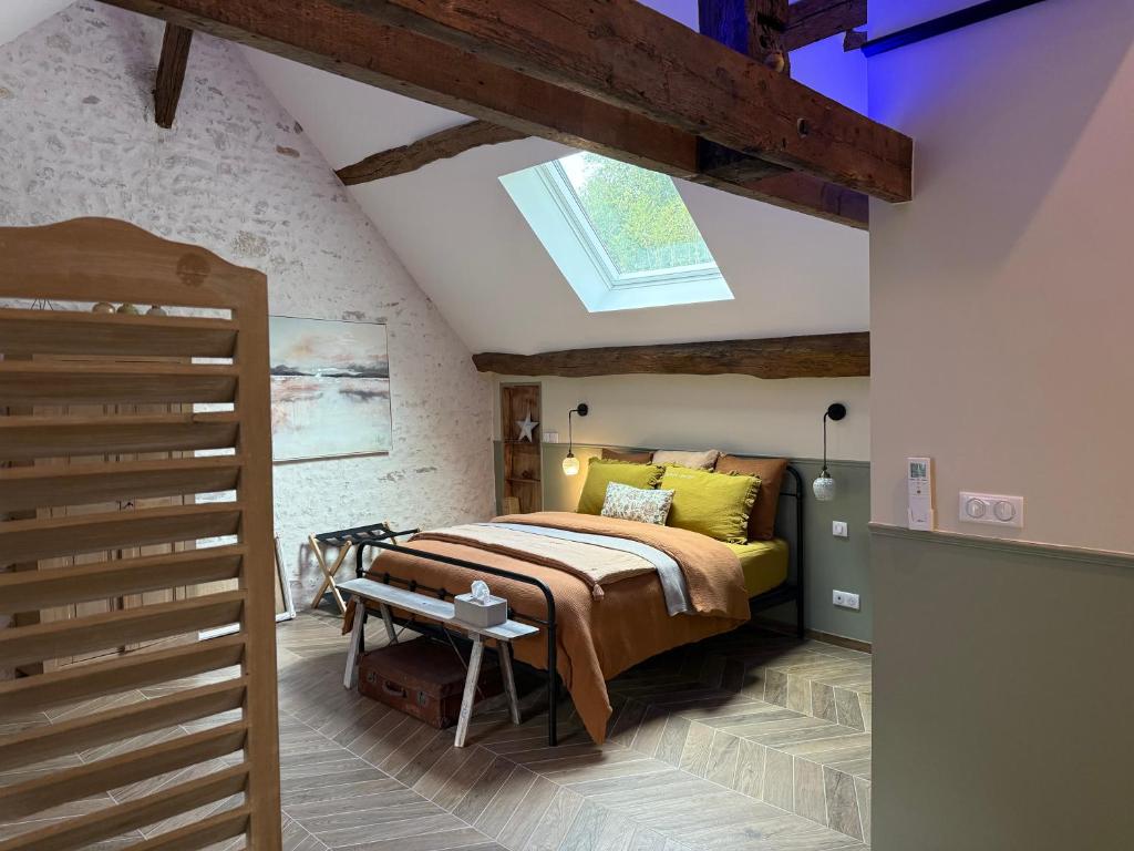 Un dormitorio con una cama y una claraboya. en Le petit jardin du Coudray, en Étréchy