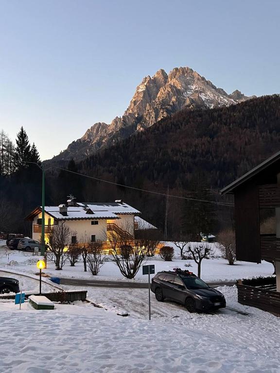 a car parked in the snow in front of a mountain at Antelao Appart in Masariè