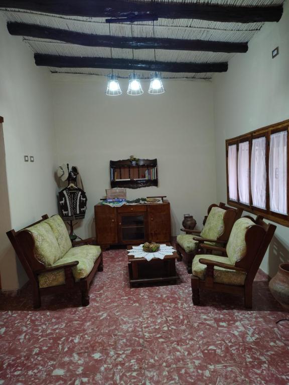 Una sala de estar con dos sillas y una mesa. en Hostal Dña Tinogasta Casa de Adobe, en Tinogasta