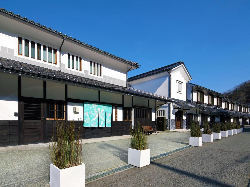 a row of buildings with potted plants in front of them at Yubaraonsen Yubaranoyado Komeya in Maniwa