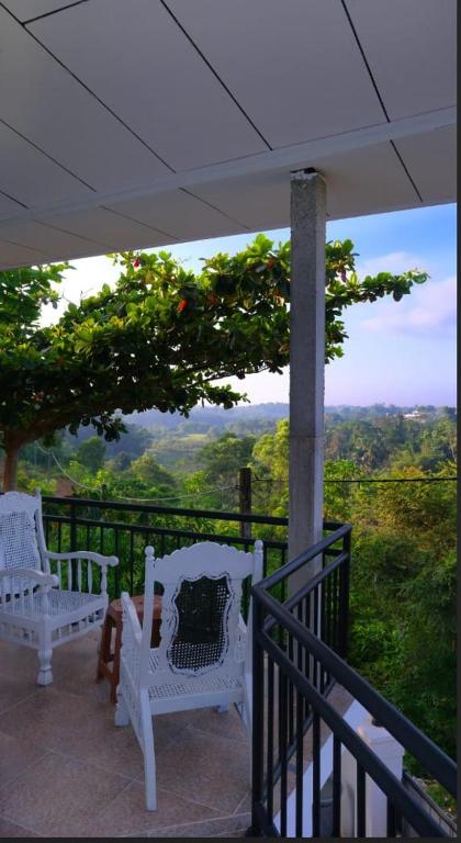 two white chairs on a balcony with a view at Ananthaya- the infinity in Wadduwa