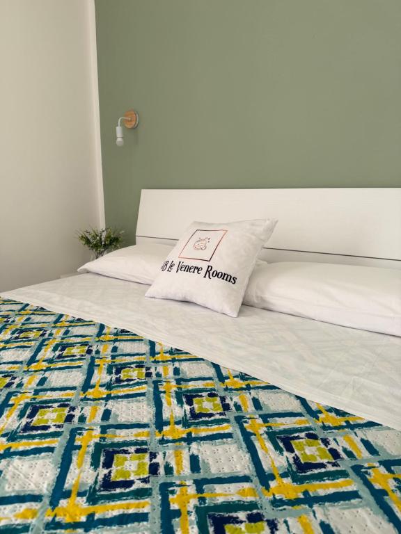 a bed with a pillow that reads the home horrors at B&B Le Venere Rooms in Castellammare del Golfo