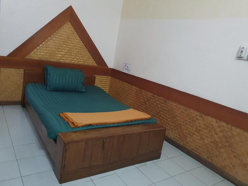 a bed with a wooden frame in a room at โรงแรมเอเซีย in Sathani Phitsanulok