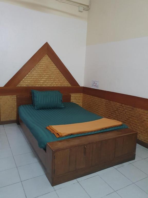 a bed with a wooden frame in a room at โรงแรมเอเซีย in Sathani Phitsanulok