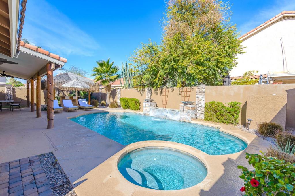 a swimming pool in the middle of a yard at Boho 4BR Retreat with Heated Pool, Spa and Tiki Bar in Gilbert