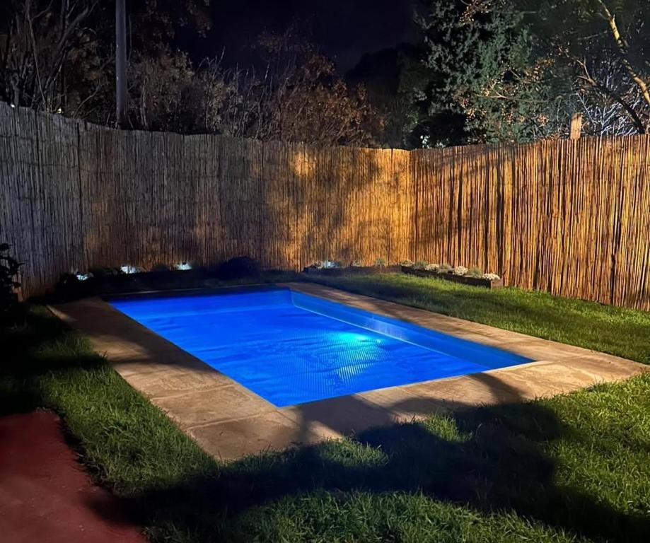 a backyard swimming pool at night with a fence at Dulce Linas titanes in Araminda