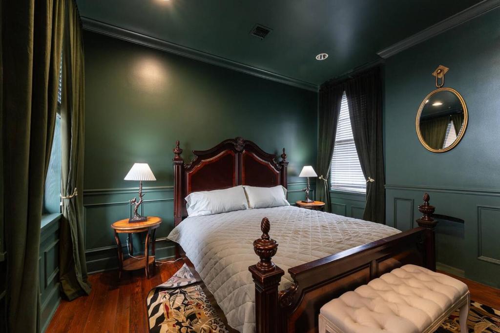 Schlafzimmer mit einem Bett mit grünen Wänden und einem Spiegel in der Unterkunft 5 New Orleans Themed Units in FQ with Pool in New Orleans