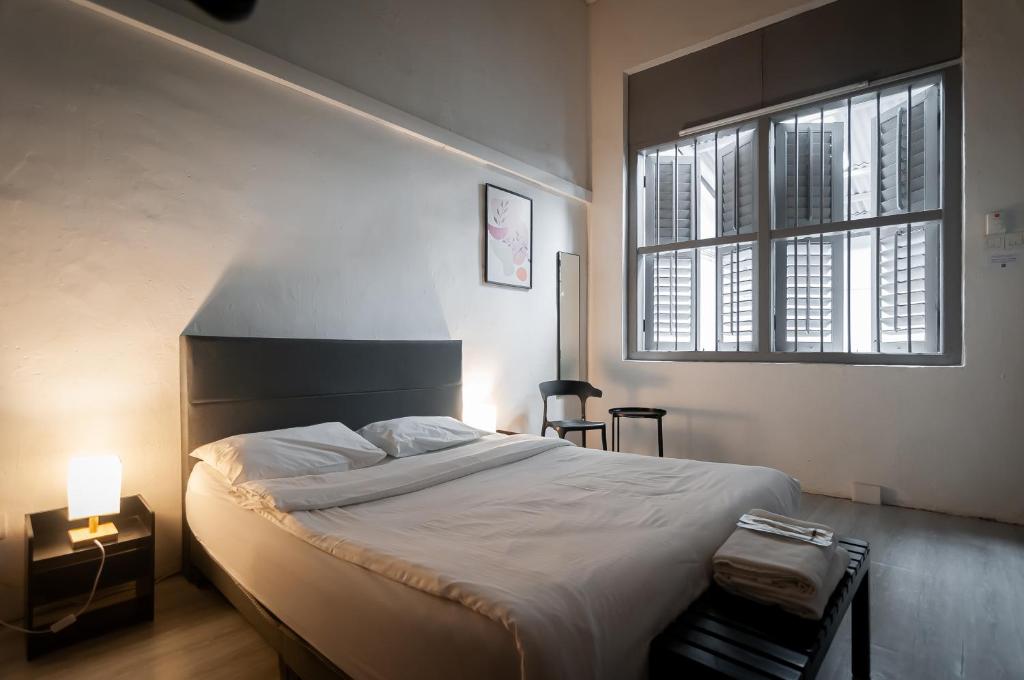 a bedroom with a large bed and a window at Aayu Melayu - George Town Penang in George Town