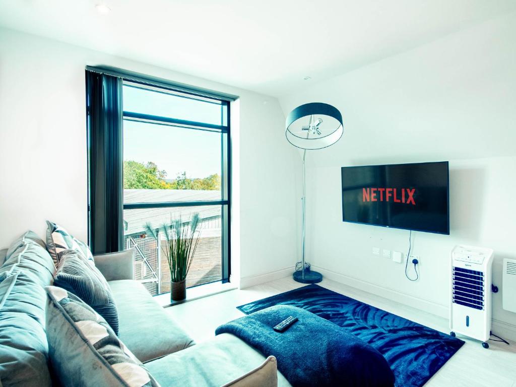 a living room with a couch and a tv at Sleek one-bedroom apartment next to Leeds Arena in Central Station