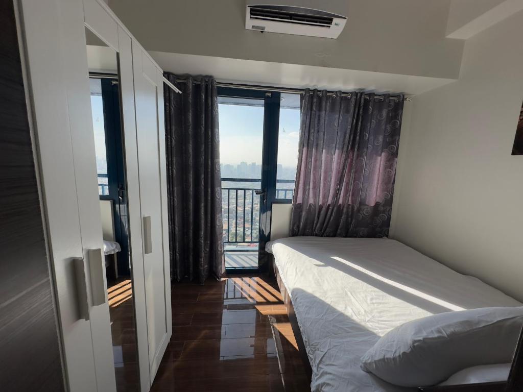 Un dormitorio con una cama con vista al mar. en Heart of Makati, Fully furnished condo, cbd central location, en Manila
